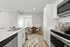 Modern kitchen featuring vinyl flooring, stainless-steel appliances, and a white quartz countertop