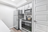 Kitchen with vinyl floors, stainless-steel appliances, and white quartz countertop
