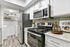 Modern kitchen featuring vinyl flooring, stainless-steel appliances, and a white quartz countertop
