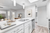 Kitchen with vinyl floors, stainless-steel appliances, white quartz countertop, and pendant lighting