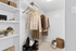 Walk in closet with vinyl wood floors, built in shelves, and clothes hanging