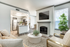 Living room with carpet, fireplace, flat-screen TV, beige chair, round coffee table, plant
