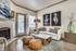 Living room with two orange ottomans, white table, white couch and wall art