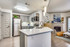 Modern kitchen with white quartz counters, stainless steel appliances and modern pendant lighting.