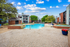 Dual pool feature with apartment exterior in back ground