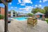 Dual pool feature and grill with apartment exterior in back ground