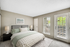Carpeted bedroom with king size bed and table lamp