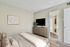 Carpeted bedroom with king size bed and flat screen TV