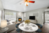 Dining table and chairs with ceiling fan, flat screen TV, couch and fire place
