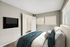 Carpeted bedroom with king size bed and flat screen TV