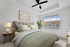 Bed with ceiling fan, side table and wall art