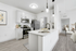 Kitchen with vinyl floors, stainless-steel appliances, white quartz countertop, and pendant lighting