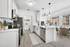 Kitchen with vinyl floors, stainless-steel appliances, white quartz countertop, and pendant lighting
