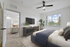 Bed, ceiling fan, TV, and window