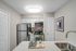 White quartz counters, stainless-steel appliances, white cabinetry