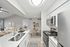 Modern kitchen featuring vinyl flooring, stainless-steel appliances, and a white quartz countertop.