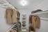 Carpeted walk in closet with clothes and built-in shelves