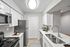 White quartz counters, stainless-steel appliances, white cabinetry