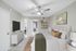 Carpeted bedroom with ceiling fan and  TV