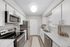Modern kitchen featuring vinyl flooring, stainless-steel appliances, and a white quartz countertop