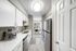 White quartz counters, stainless-steel appliances, white cabinetry