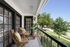 Balcony with wooden furniture looking over greenery