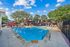 swimming pool with spa and sundeck with outdoor grilling area in background