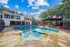 swimming pool with spa, outdoor grilling area, and leasing office in the background