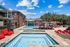 swimming pool with sundeck surrounded by apartment buildings