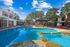 swimming pool with spa, outdoor grilling area, and leasing office in the background