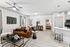 Living space with wood floors, ceiling fan, and brown couch and table