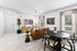 Living space with wood floors, ceiling fan, and brown couch and table