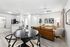 Living space with wood floors, ceiling fan, and brown couch and table