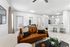 Living space with wood floors, ceiling fan, and brown couch and table