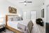 Carpeted bedroom with ceiling fan, bed, and window