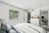 Bright and inviting bedroom with modern decor, featuring a comfortable bed, large window with a garden view, and an open closet leading to a cozy living area.