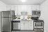 Elegant kitchen with sleek stainless steel appliances, white cabinetry, and marble countertops, creating a modern and inviting atmosphere.