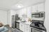 Modern kitchen with sleek stainless steel appliances, elegant white cabinetry, and a chic marble countertop.