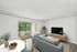 Bright and airy living room featuring modern decor, large sliding doors with garden view, and stylish dining area with natural accents.