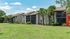 Charming apartment complex with lush greenery and palm trees, offering serene living spaces and sunny balconies.
