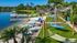 Idyllic lakeside retreat with hammocks and a sandy beach, featuring a serene dock and tropical palm trees.