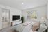 Bright and inviting bedroom with a large window, cozy bed, and stylish decor, leading to a modern open-plan living area with natural light.