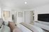 Inviting bedroom featuring a cozy bed, stylish decor, flat-screen TV, and spacious walk-in closet.