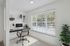 Bright home office nook with a large window, modern desk setup, and lush greenery, perfect for productivity and inspiration.