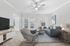 Bright and inviting living room with modern furniture, cozy blue couch, and large windows letting in natural light.