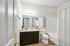 Modern bathroom with elegant wooden flooring, sleek vanity, and bright lighting.