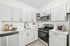 Modern kitchen with sleek white cabinetry, stainless steel appliances, and stylish subway tile backsplash.