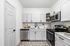 Contemporary kitchen with sleek white cabinets, stainless steel appliances, and elegant subway tile backsplash.