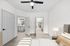 Bright bedroom with modern ceiling fan, cozy lamp, and access to spacious closet and elegant bathroom.