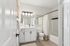 Luxurious bathroom with elegant lighting, modern vanity, and classic white tub.